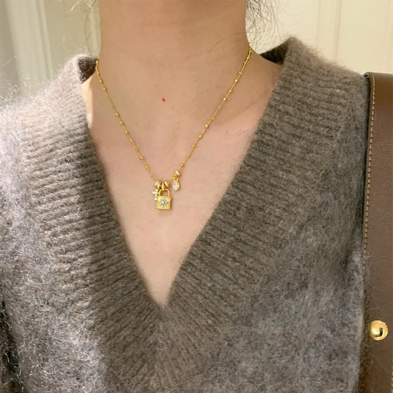 Elegantní náhrdelník s přívěskem kříže a zámku - elegantní zlatý řetězec s křišťálovými kouzly